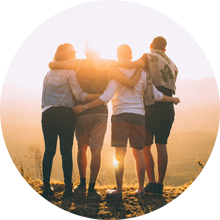 Four Travelers hugging at sunset